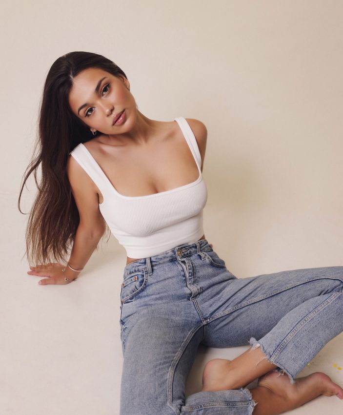 Torrance Wellness Coaching model in a white top and jeans sitting on the floor